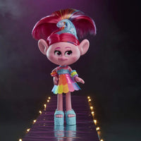 Bambola trolls poppy con pelle rosa vivace e coda arcobaleno in gonna a strati su passerella riflettente
