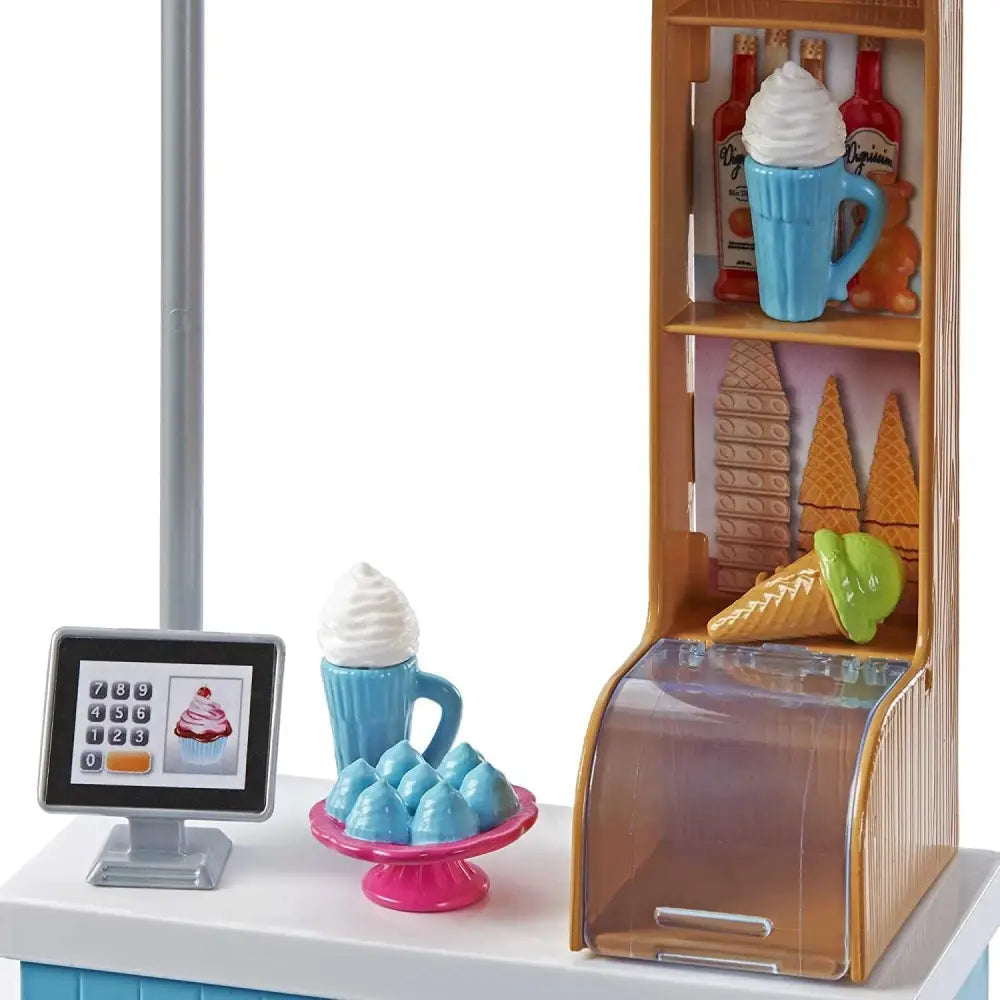 Bicchiere di plastica blu con panna montata bianca nel barbie set bambola e gelateria con bambola bionda