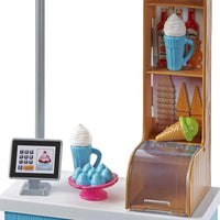 Bicchiere di plastica blu con panna montata bianca nel barbie set bambola e gelateria con bambola bionda