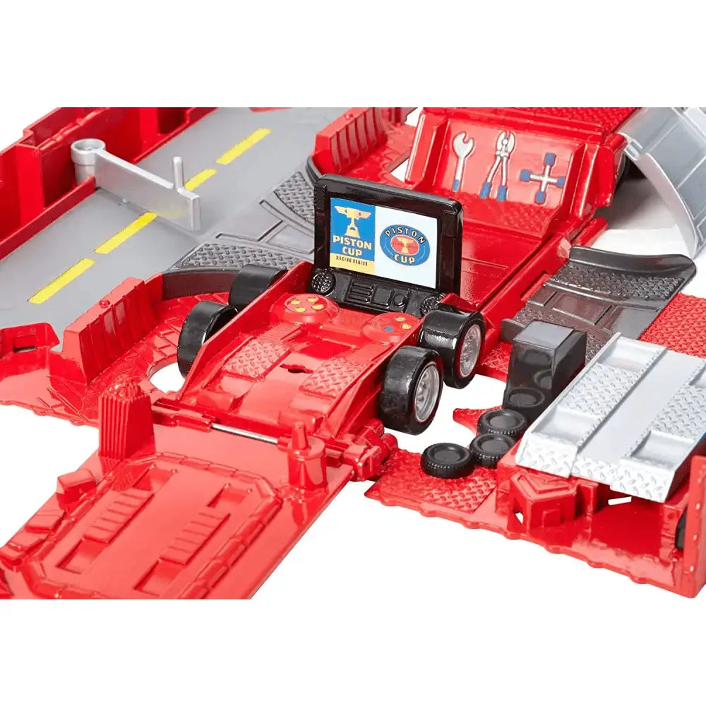 Rosso giocattolo auto da corsa con motore dettagliato su pista rossa playset trasportatore camion film disney