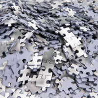 Una pila di pezzi grigi di puzzle con linguette e incastri per il d10s maradona puzzle 1000 pezzi