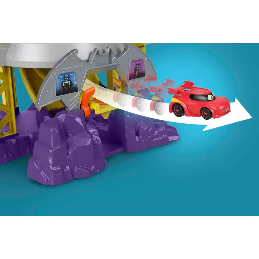 Red e gialla macchina giocattolo che corre sulla pista del playset fisher-price dc batwheels batcaverna lancia sfreccia