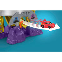 Red e gialla macchina giocattolo che corre sulla pista del playset fisher-price dc batwheels batcaverna lancia sfreccia