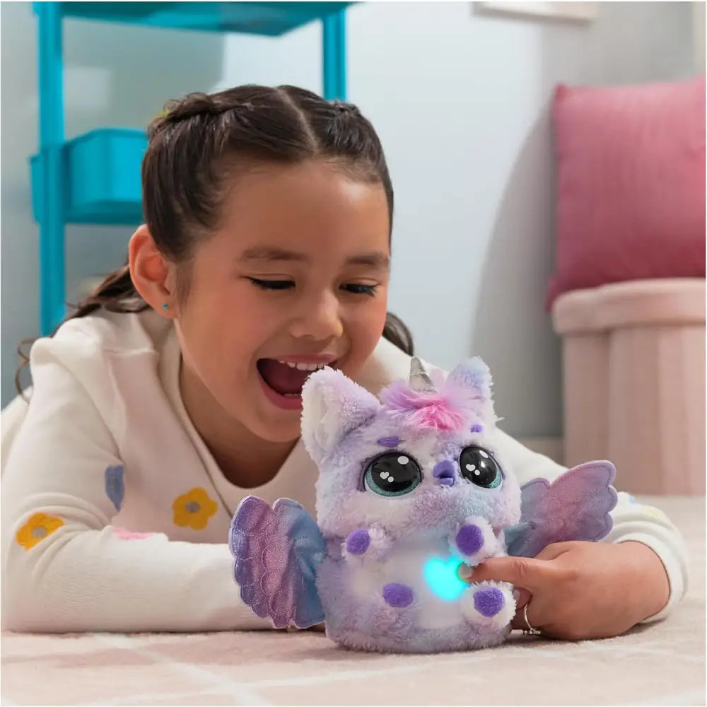 Unicorno di peluche viola e rosa con ali e luci blu sul petto hatchimals alive uovo mystery hatch pufficorn
