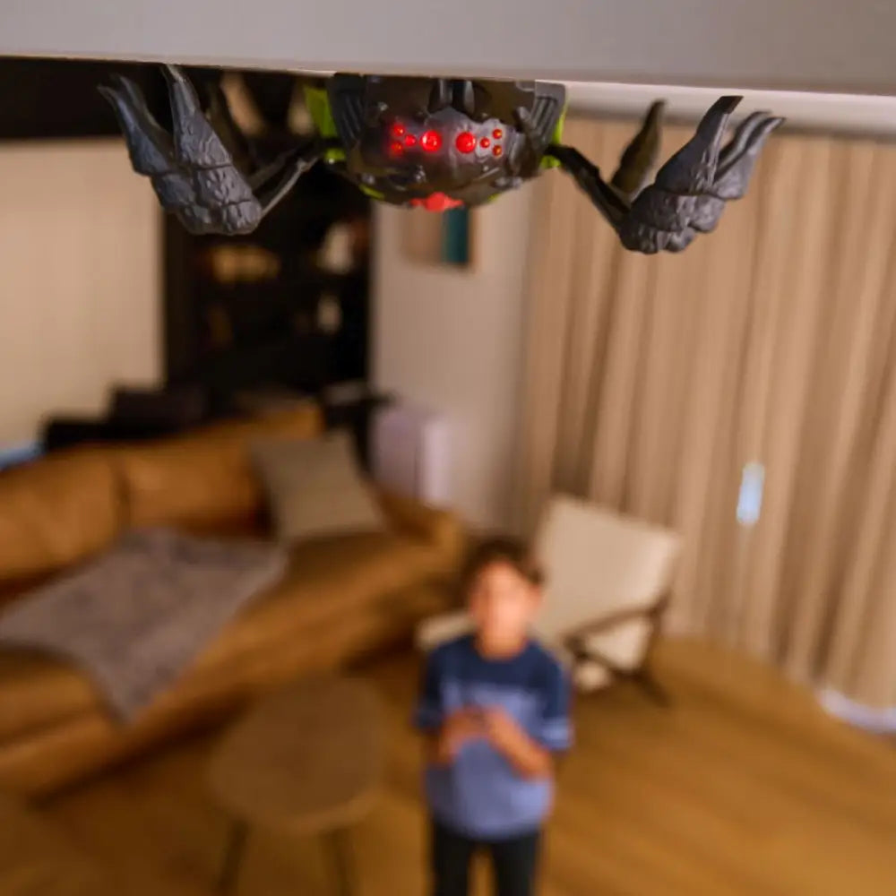 Robot ragno nero e verde hex bots che si arrampica con telecomando occhi rossi luminosi appeso al soffitto