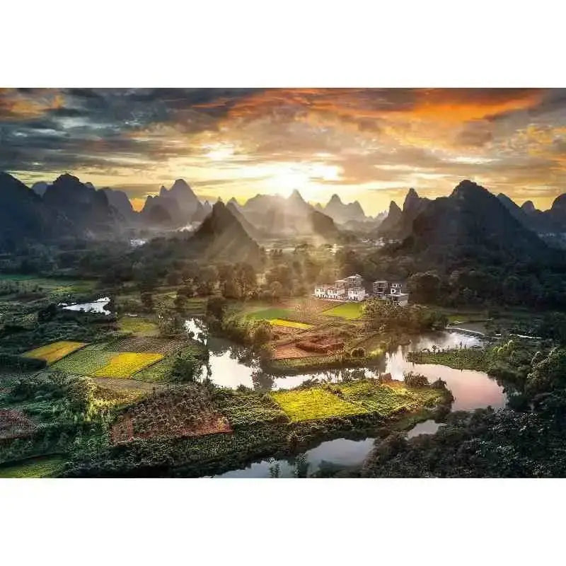 Puzzle 2000 pezzi con panorama cinese di tramonto su valle con montagne carsiche fiumi e campi verdi